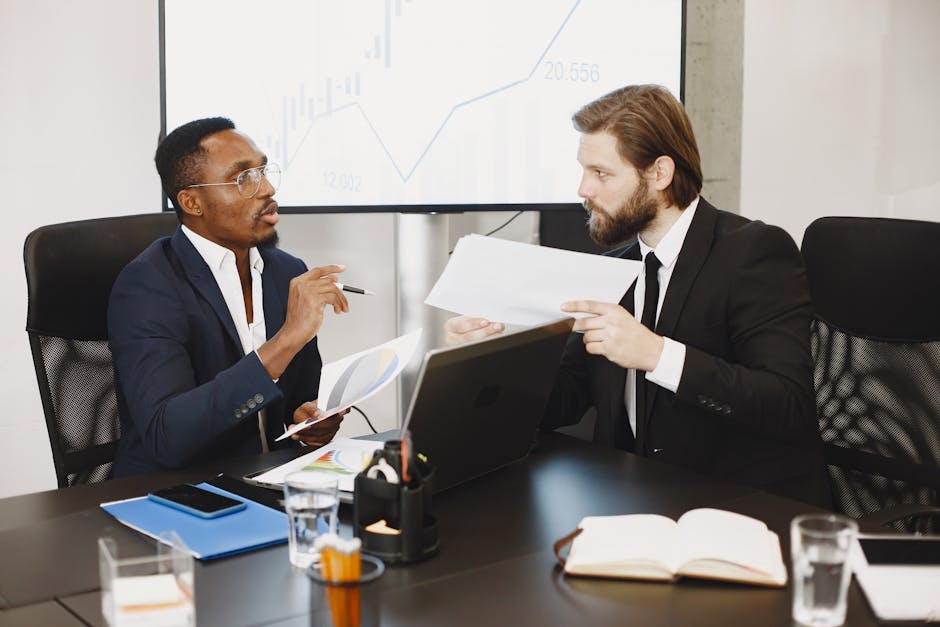 Two business professionals engaged in a planning meeting, discussing documents in a modern office setting